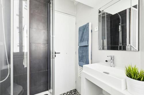une salle de bain blanche avec un lavabo et une douche dans l'établissement Lovely top floor studio near Montmartre, à Paris