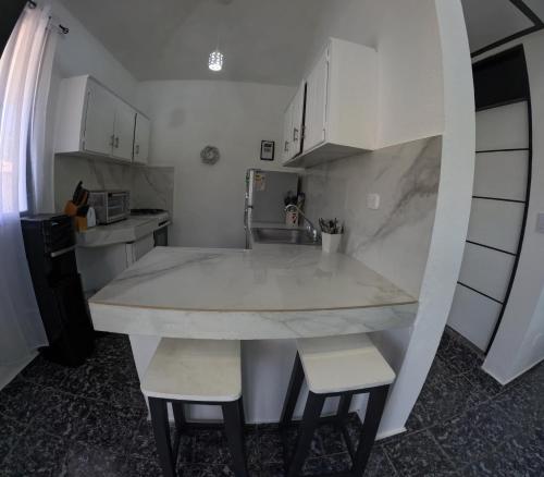 eine Küche mit einer großen Marmortheke und 2 Stühlen in der Unterkunft Hotel El Legendario in Sosúa