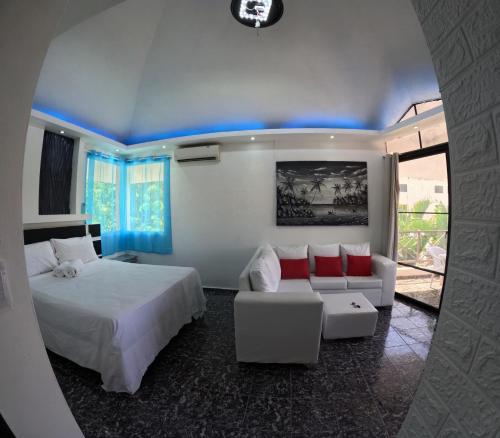 ein Schlafzimmer mit einem Bett und einem Sofa in einem Zimmer in der Unterkunft Hotel El Legendario in Sosúa