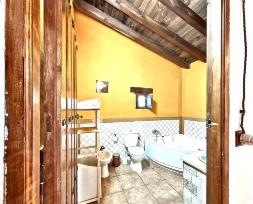 La salle de bains est pourvue d'une baignoire, de toilettes et d'un lavabo. dans l'établissement 9 bedrooms villa with private pool jacuzzi and enclosed garden at Granada, à Grenade