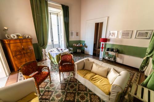 コゼンツァにあるDimora Storica Giostra Vecchia - Palazzo Grisolia 1809のリビングルーム(ソファ、椅子付)