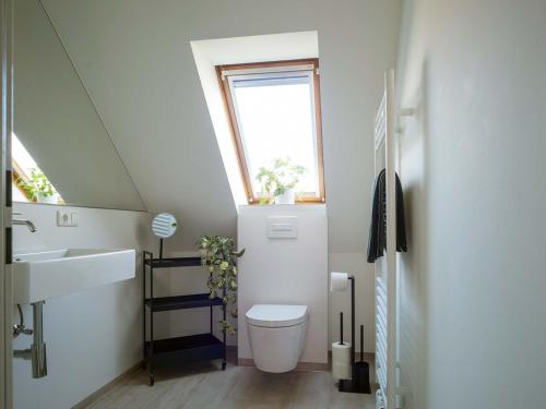 a bathroom with a toilet and a sink and a window at Trabbi-Haus in Harlesiel