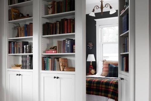 a room with white book shelves filled with books at Goyke -Gorgeous Lakefront in Van Dyne