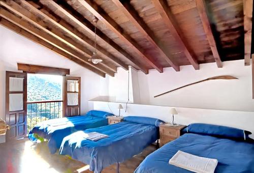 - 2 lits dans une chambre avec des draps bleus dans l'établissement 9 bedrooms villa with private pool jacuzzi and enclosed garden at Granada, à Grenade
