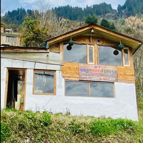 a building with a sign on the side of it at WTF! What The Forest vashisht manali in Manāli