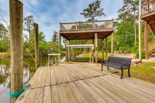 a wooden deck with a bench on the water at Bayou La Batre Stilted House on Snake Bayou! in Bayou La Batre