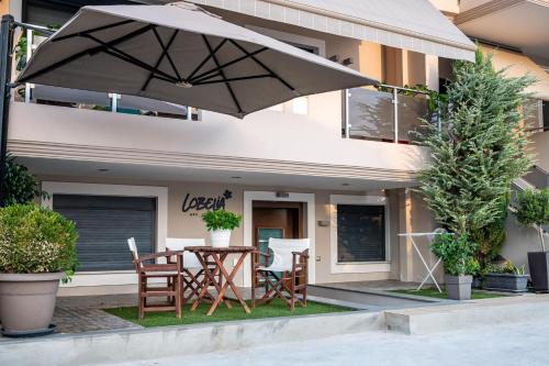 a patio with a table and chairs and an umbrella at Lobelia Nafplio Apartments in Nafplio