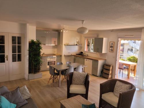 une cuisine et un salon avec une table et des chaises dans l'établissement Bel appartement 2 chambres proche plage et golfs by Beds83, à Saint-Raphaël