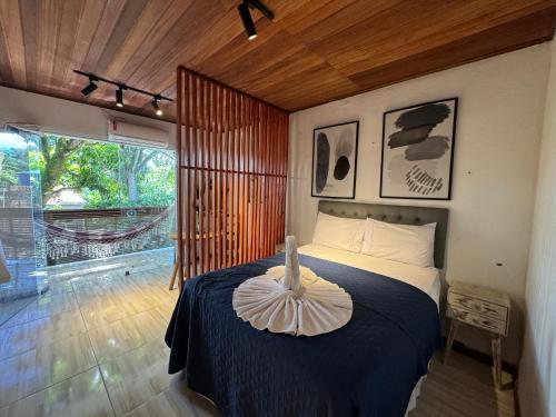 Schlafzimmer mit einem Bett mit blauer Decke in der Unterkunft Apartamento Pituba Jardim in Itacaré