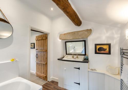 y baño con lavabo, espejo y bañera. en Newby Cottage en Newby