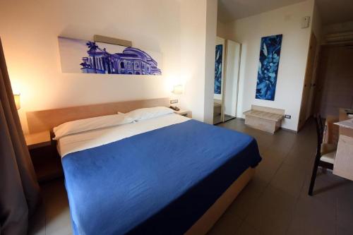 a bedroom with a blue bed in a room at Hotel Villa d'Amato in Palermo