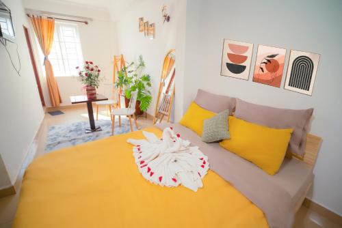 a bedroom with a yellow bed with yellow pillows at Pearl Wealth Dalat Hotel in Da Lat