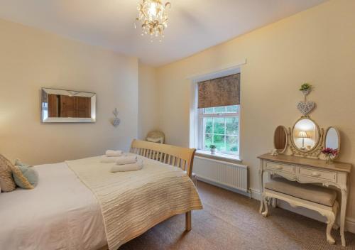 a bedroom with a bed and a window and a mirror at Viaduct View in Ingleton