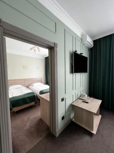 a bedroom with a bed and a mirror and a tv at AQ-JAIYQ in Karagandy