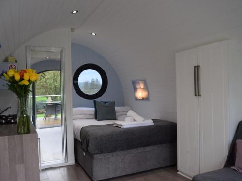 a bedroom with a bed and a vase of flowers at The Kingfishers Burrow in Llandovery