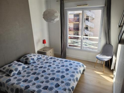 une chambre avec un lit, une fenêtre et une chaise dans l'établissement Bel appartement 2 chambres proche plage et golfs by Beds83, à Saint-Raphaël