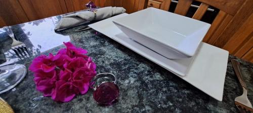 a table with a plate and a purple flower on it at The Palm Villa in St Paul's Bay