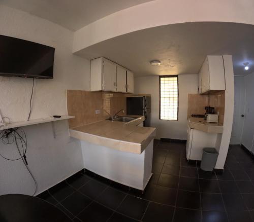 a kitchen with a sink and a counter top at Hotel El Legendario in Sosúa