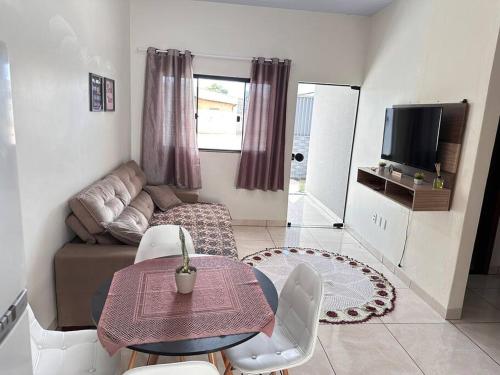 ein kleines Wohnzimmer mit einem Tisch und einem Sofa in der Unterkunft Casa bem localizado em Sinop in Sinop