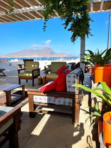 a couch on a patio with a view of the ocean at Casa de Poço Guest House and Gallery in Mindelo