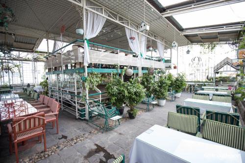 a restaurant with tables and chairs and potted plants at Khách sạn Minh Châu - Hòa Hưng in Ho Chi Minh City