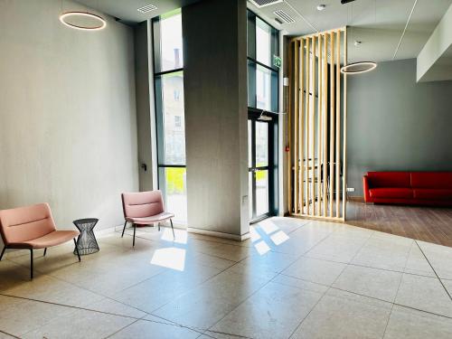 una hall con due sedie e un divano rosso di Bel Dom - The Central, spacious 2 rooms luxury apartment a Cluj-Napoca