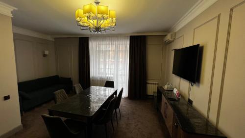 a living room with a dining table and a television at AQ-JAIYQ in Karagandy