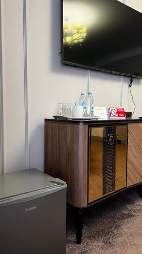 a flat screen tv on top of a wooden entertainment center at AQ-JAIYQ in Karagandy