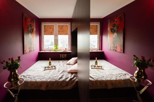 a purple room with a bed with two bottles on it at Apartament Jacuzzi in Gdynia