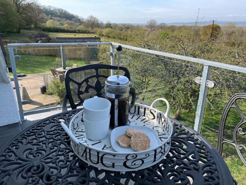 a table with a plate of food on a balcony at Y Llofft, Llanrhidian, Gower in Swansea