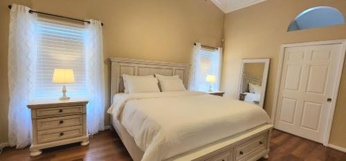 - une chambre avec un lit, une commode et un miroir dans l'établissement Luxury 3-Bedroom Home near Beaches with Pool, à Vero Beach