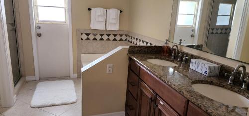 a bathroom with two sinks and a large mirror at Luxury 3-Bedroom Home near Beaches with Pool in Vero Beach