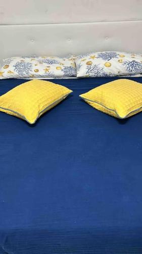 Una cama con dos almohadas amarillas encima. en Nanà casa vacanza en Capri