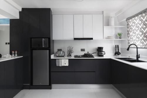 una cocina con armarios y electrodomésticos en blanco y negro en Blue Haven by Sunspot Global Properties Ltd., en Abuja