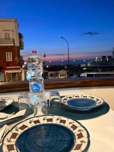 una mesa con dos platos y una botella de agua en Nanà casa vacanza en Capri