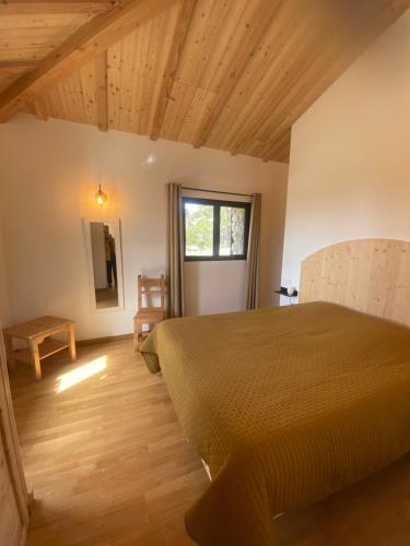 Schlafzimmer mit einem Bett und Holzboden in der Unterkunft La Bergerie Chalet Ventoux Sud in Bédoin