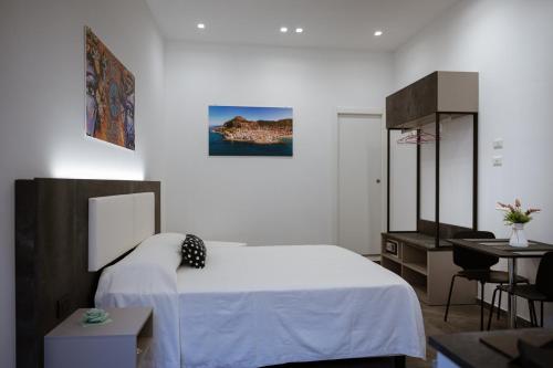 ein Schlafzimmer mit einem Bett, einem Tisch und einem Schreibtisch in der Unterkunft Family House in Cefalú