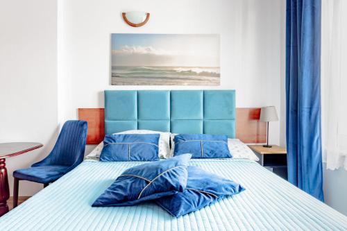 a bedroom with a bed with a blue headboard at Pokoje Gościnne Miła 12 - Bardzo Blisko Plaży in Karwia