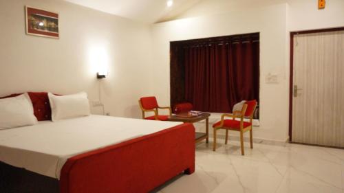 a bedroom with a bed and chairs and a table at Wow Relish in Alwar