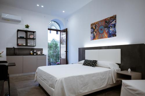 - une chambre avec un grand lit blanc et une fenêtre dans l'établissement Family House, à Cefalù