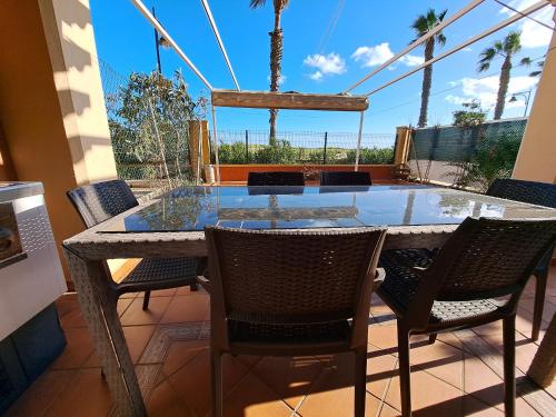 einen Tisch und Stühle auf einer Terrasse mit Aussicht in der Unterkunft Residencial Alcaraván, Isla Canela - By AC REAL in Isla Canela