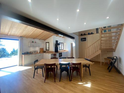 eine Küche und ein Esszimmer mit einem Holztisch und Stühlen in der Unterkunft La Bergerie Chalet Ventoux Sud in Bédoin