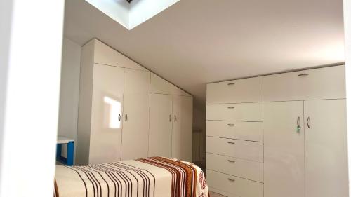 1 dormitorio blanco con 1 cama y armarios blancos en SE058 - Senigallia, pentalocale comodo ai servizi, en SantʼAngelo