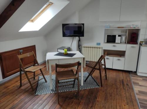 een kamer met een tafel en stoelen en een keuken bij Le Faubourg in Saint-Quentin