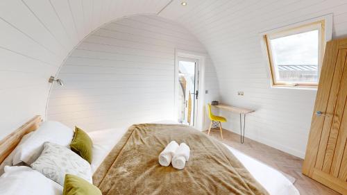 een slaapkamer met een bed met witte schoenen erop bij Bromach Lodge in Latheron