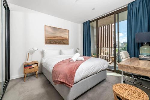 1 dormitorio con cama, escritorio y ventana en London Circuit City Escape, en Canberra