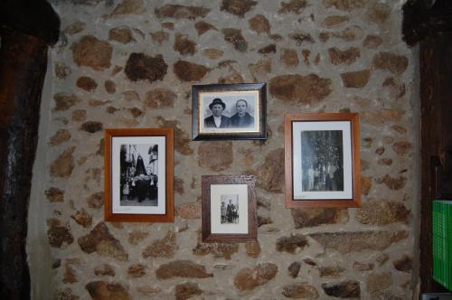 a wall with four pictures on a stone wall at Apartamentos Rurales Tía Josefa in Tornavacas