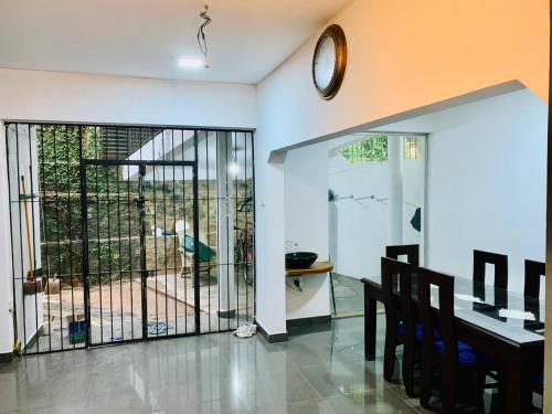 ein Esszimmer mit einem Tisch und einer Uhr an der Wand in der Unterkunft Privet Home Stay in Wattala