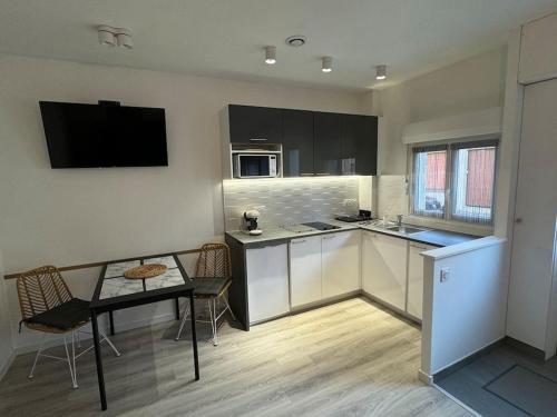 une cuisine avec une table et une petite table sidx sidx sidx sidx dans l'établissement Appartement à 200 m de la plage, à Berck-sur-Mer