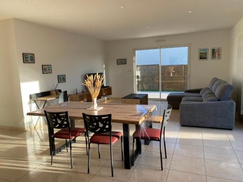 a living room with a wooden table and chairs at 1100-Maison au cœur du village de Planguenoual. in Planguenoual